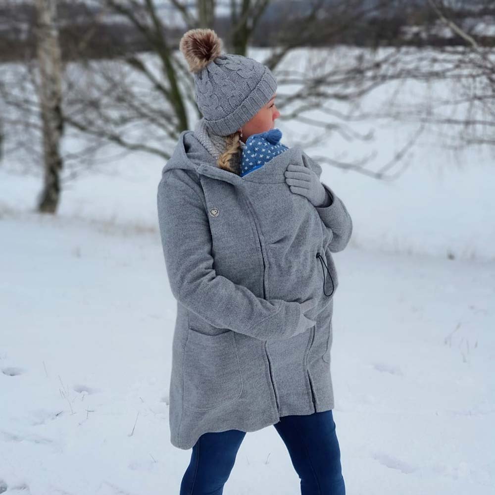 Winter Tragemantel Baby und Mama im Schnee unter einer Jacke